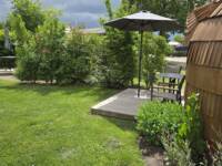 Urlaubsnest 2026 01 Urlaubsnest von außen mit Terrasse und Sonnenschirm